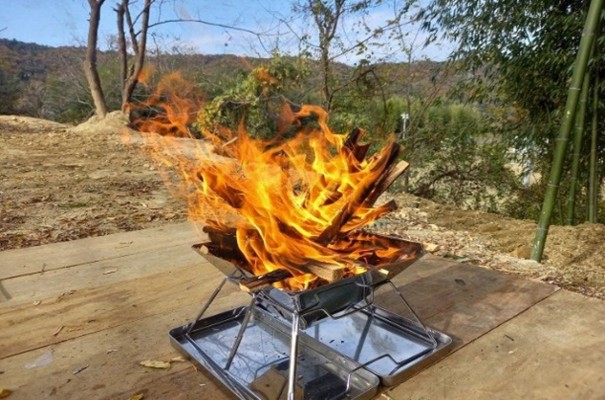 銀色の焚き火台の上で焚き火をしている