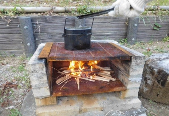 かまどで飯盒を使用しご飯を炊く