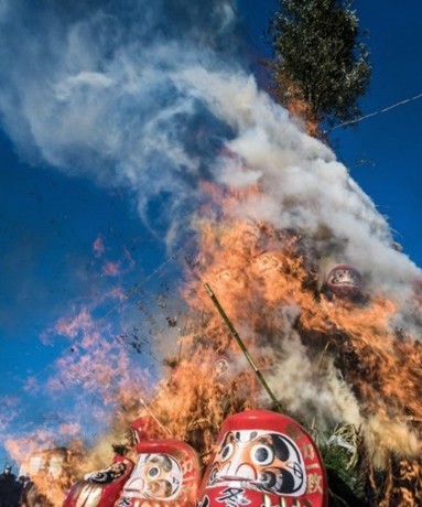 青空の下達磨をどんど焼きで燃やす