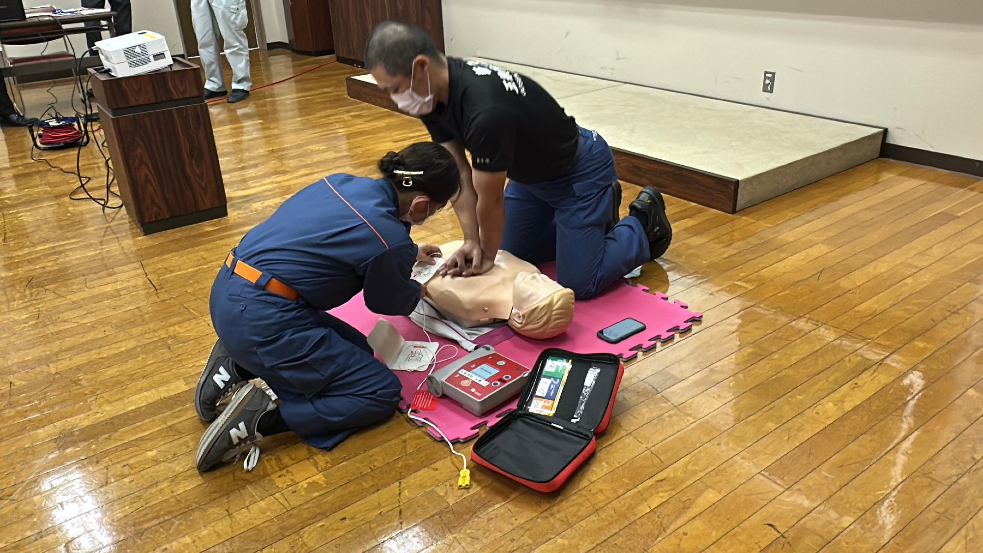 普通救命講習で講師が心肺蘇生法の見本を見せている
