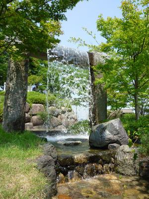 南公園の樹木と噴水カーテンが癒しを与える様子の写真